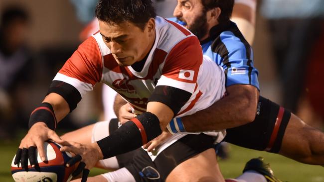 Japan’s Ayumu Goromaru scores a try while Uruguay’s Santiago Gilbernau tackles.