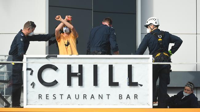 A protester gestures as police escorts them away. Picture: AAP Image/James Ross