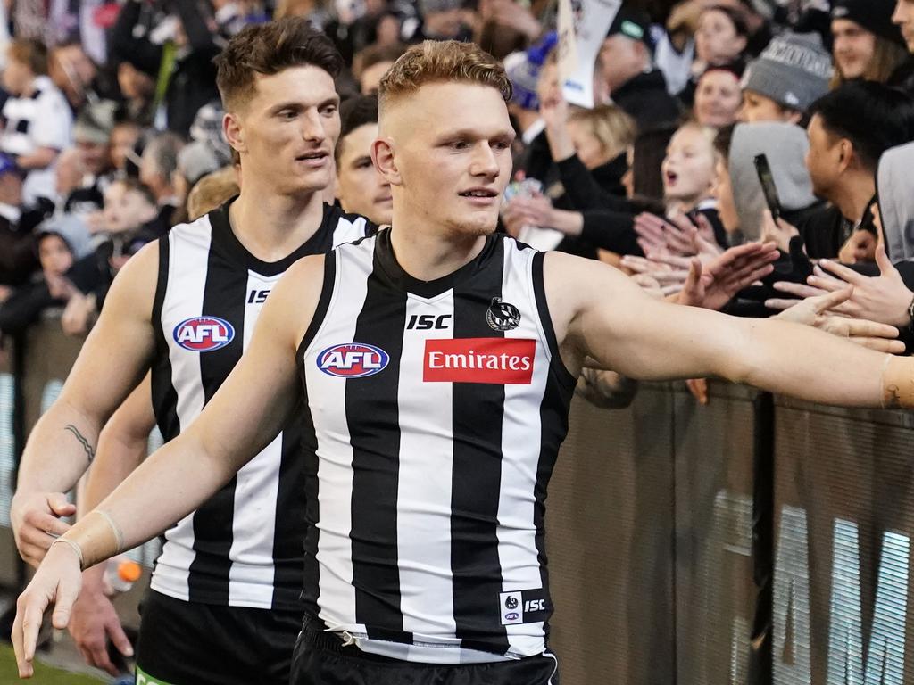 Adam Treloar celebrates with Pies fans at the MCG.