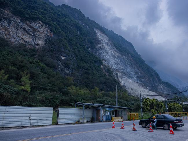 A man guards a checkpoint along a road near a landside following a 7.5 magnitude earthquake, which hit eastern Taiwan. Picture: Getty Images