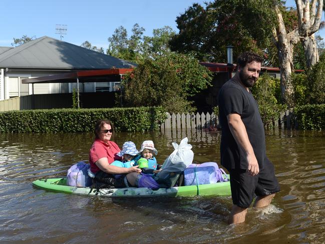 Residents of Geoffrey Road in Chittaway Bay, take to the flooded street in water craft. Picture: Jeremy Piper