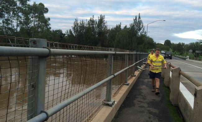 Gympie council workers clearing debri from Kidd Bridge early this morning . Picture: Frances Klein