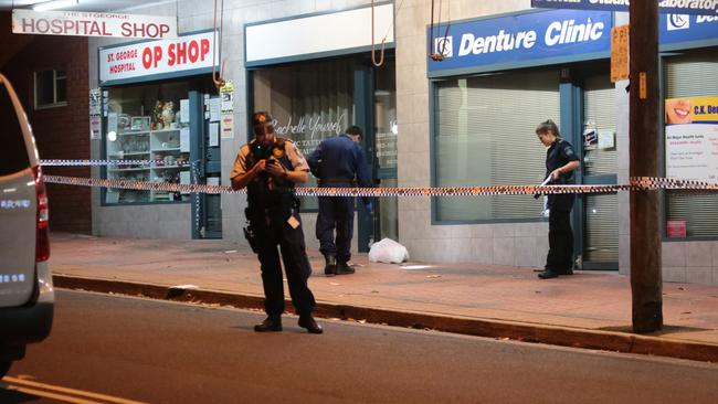 Forensics investigate the pavement outside the studio. Picture: Damian Hoffman