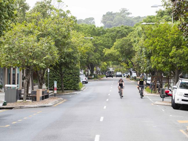 Cyclists ride down a desolate Hastings street in Noosa on Good Friday 2020, which would normally be teeming with thousands of Easter Holiday Makers. Photo Lachie Millard