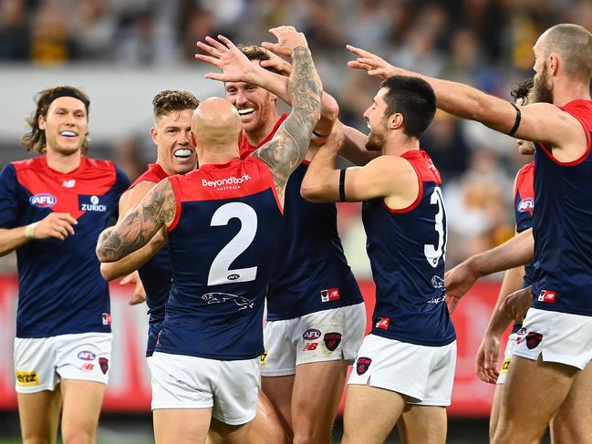 MELBOURNE, AUSTRALIA - APRIL 18: Mitch Brown of the Demons is congratulated by team mates after kicking a goal during the round five AFL match between the Hawthorn Hawks and the Melbourne Demons at Melbourne Cricket Ground on April 18, 2021 in Melbourne, Australia. (Photo by Quinn Rooney/Getty Images)