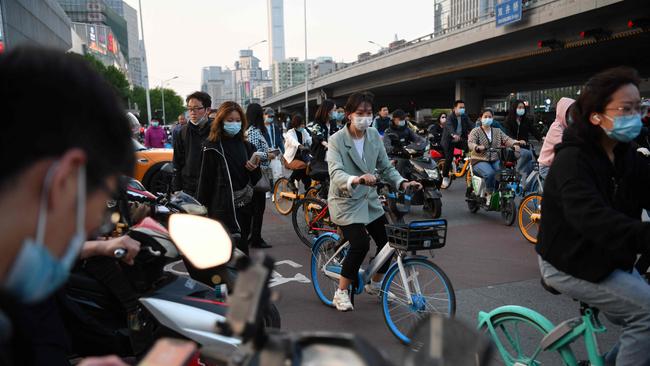 Cyclists and pedestrians cross an intersection during rush hour in Beijing. Picture: AFP