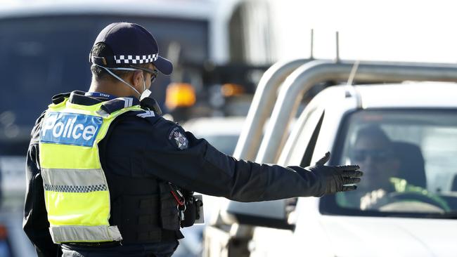 Police perform checks at a roadblock on the Princes Freeway just before Little River. Picture: Darrian Traynor/Getty Images.