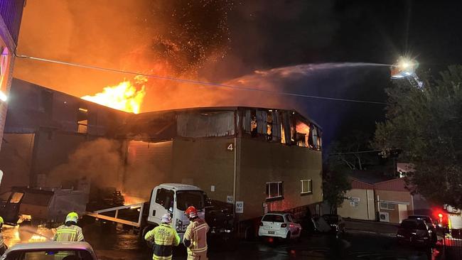 Firefighters battle to contain a large blaze that has engulfed a factory complex at Brookvale on Monday, night, containing a tyre and mechanical workshop. Picture: Fire and Rescue NSW