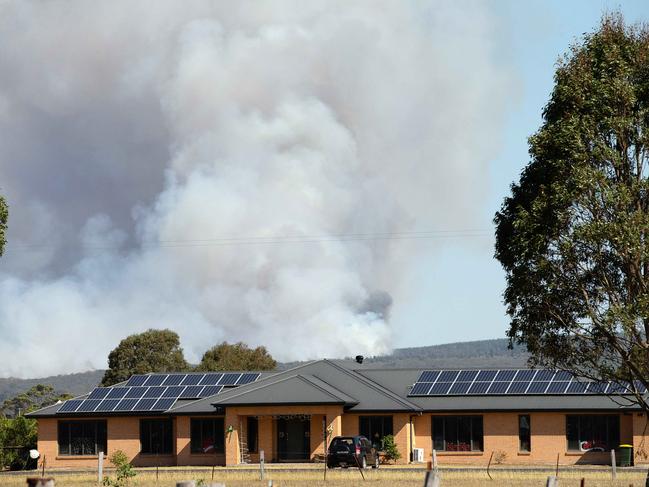 Smoke billows close to a house near Rosedale. Picture: Mark Stewart