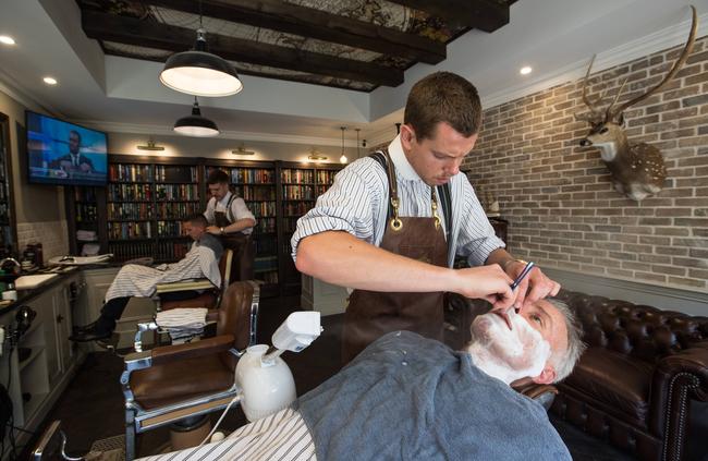 Luke Benicky gives a customer, Stephen Levy, a hot towel shave. Picture: Julian Andrews