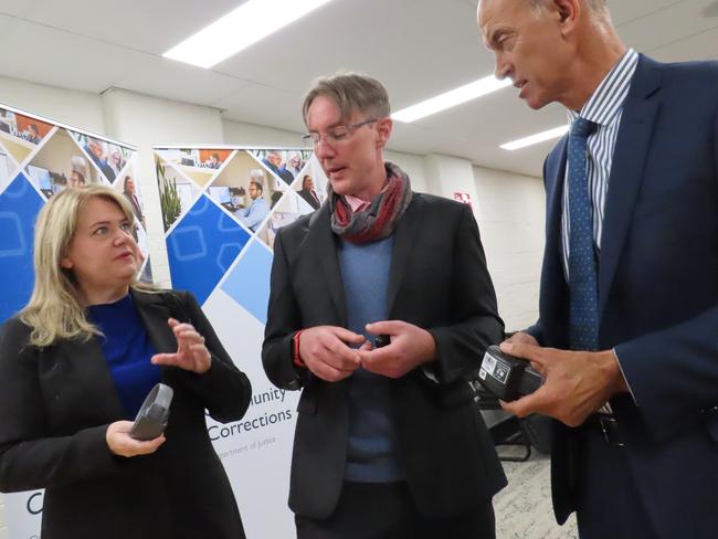 Minister for Corrections and Rehabilitation Madeleine Ogilvie, Community Corrections executive director Chris Carney and Attorney-General Guy Barnett inspect ankle bracelets at the Community Corrections Monitoring and Compliance Unit in Hobart on Thursday, February 6, 2025.