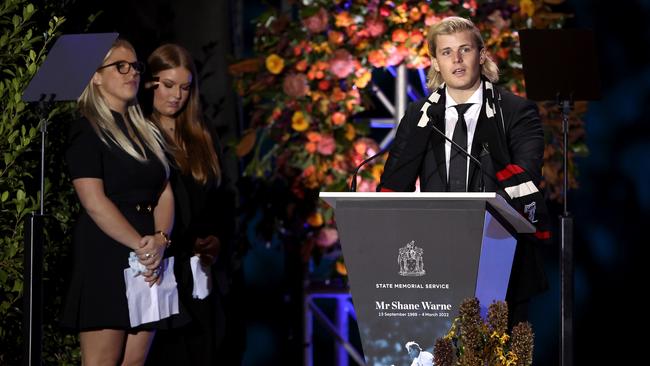 Jackson Warne speaks on stage alongside Summer Warne and Brooke Warne