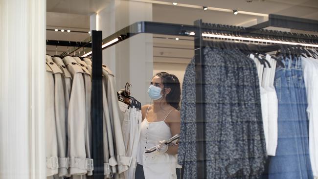 A worker changes clothes rails in a store on Oxford Street in London. Picture: Getty Images