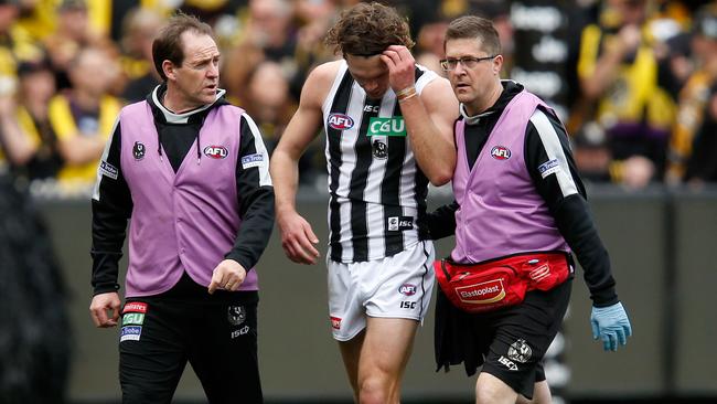 Matthew Scharenberg is helped from the ground after injuring his knee.