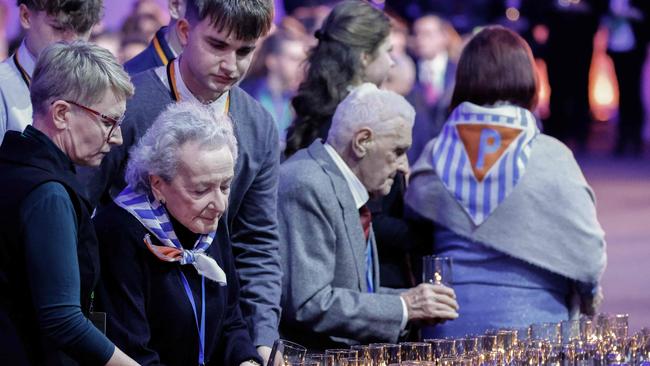 Holocaust survivor Nusia Horowitz (second from left) lays a candle at the Auschwitz concentration camp site on Tuesday in Oswiecim, Poland, during commemorations on the 80th anniversary of the liberation of the German Nazi concentration and extermination camp Auschwitz-Birkenau by the Red Army. Picture: AFP