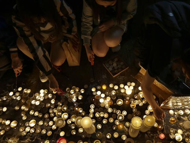 Protesters light candles to pay homage to Chow Tsz-Lok at the site where he fell in Hong Kong. Picture: AP