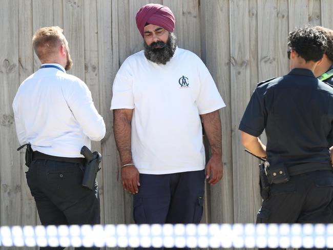 Police talk to a man who lifted police tape and ran onto the crime scene. Picture: David Crosling