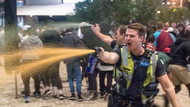 Police officers use pepper spray during the brawl. Picture: Jake Nowakowski