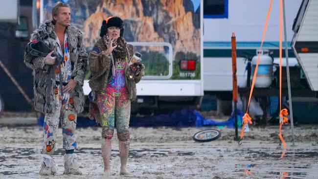 Ben Joos of Nevada and Dub Kitty of Idaho try to figure out which way to walk in the mud at Burning Man after a night of dancing with friends.