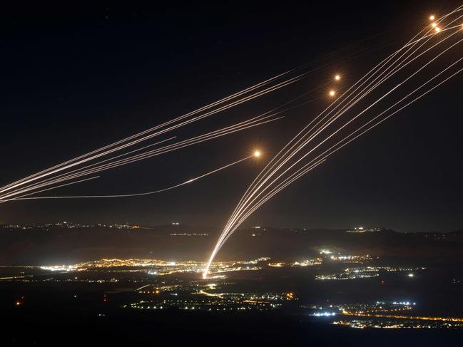 Rockets fired from southern Lebanon are intercepted by Israel's Iron Dome air defence system over the Upper Galilee region in northern Israel, on August 4, 2024, amid ongoing cross-border clashes between Israeli troops and Lebanon's Hezbollah fighters. Middle East tensions soared Saturday as Iran and its allies readied their response to the assassination of Hamas's political leader, blamed on Israel, spurring fears of a regional war. (Photo by Jalaa MAREY / AFP) / âThe erroneous mention[s] appearing in the metadata of this photo by Jalaa MAREY has been modified in AFP systems in the following manner: [Druze men in the village of Ain al-Tineh] instead of [Druze elders in the Israeli-annexed Golan Heights village of Majdal Shams ]. Please immediately remove the erroneous mention[s] from all your online services and delete it (them) from your servers. If you have been authorized by AFP to distribute it (them) to third parties, please ensure that the same actions are carried out by them. Failure to promptly comply with these instructions will entail liability on your part for any continued or post notification usage. Therefore we thank you very much for all your attention and prompt action. We are sorry for the inconvenience this notification may cause and remain at your disposal for any further information you may require.â