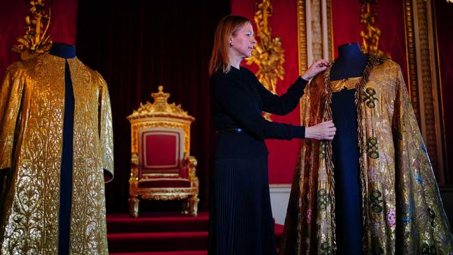 Caroline de Guitaut, deputy surveyor of the King's Works of Art for the Royal Collection Trust, adjusts the Imperial Mantle, which forms part of the Coronation Vestments in the Throne Room at Buckingham Palace. The vestments will be worn by King Charles III during his coronation at Westminster Abbey on Saturday. Picture: Victoria Jones/Pool/AFP