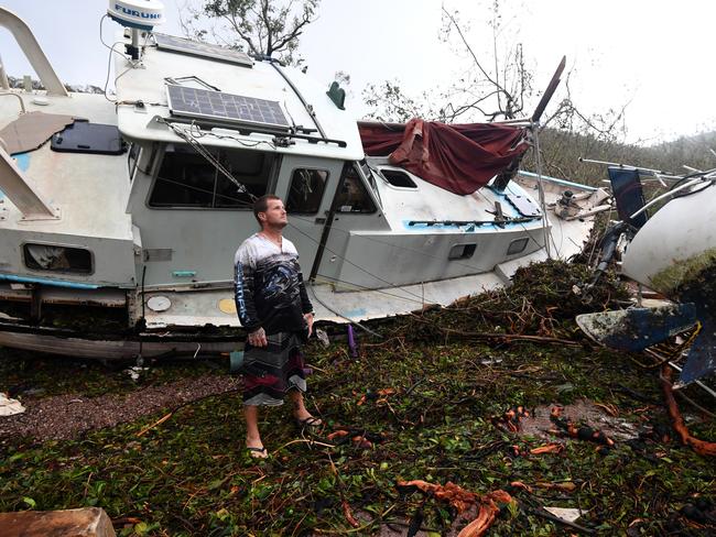 Bradley Mitchell inspects the damage to his uncle’s boat after it smashed against the bank at Shute Harbour, Airlie Beach, Wednesday, March 29, 2017. Picture: AAP Image/Dan Peled