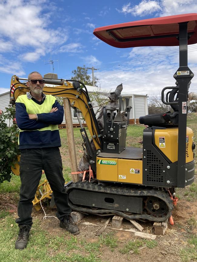 Mark Henshall with his broken Agrison ME1000 Mini Excavator that has sat on his nature strip for over 12 months awaiting for it to be collected and repaired.