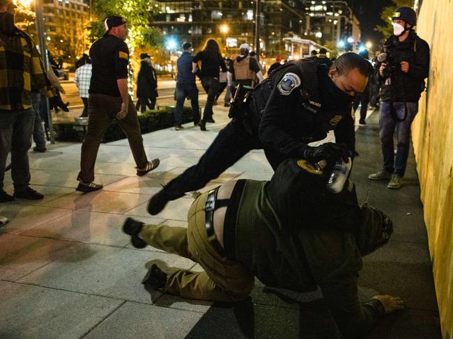 A police officer arrests a member of the Proud Boys during clashes following the Million MAGA March. Picture: Getty Images/AFP