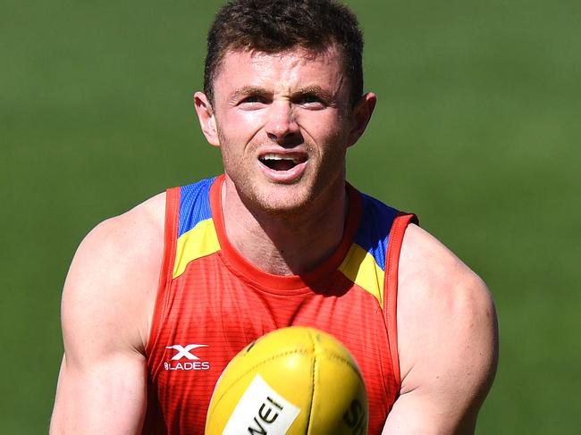 Pearce Hanley handballs during the Gold Coast Suns training session at Metricon Stadium on the Gold Coast, Friday, July 28, 2017. (AAP Image/Dave Hunt) NO ARCHIVING