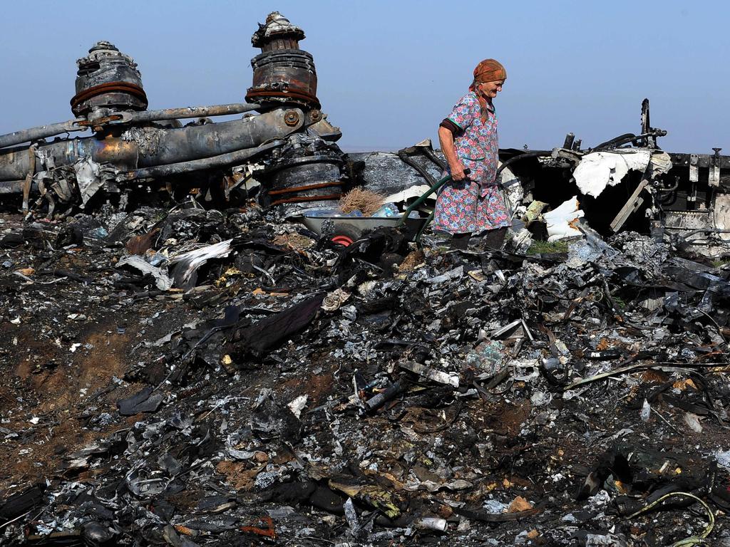 An elderly woman, walks among the wreckage of flight MH17, near the village of Rassipnoe. Picture: AFP