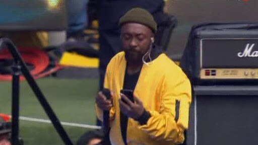 Will i am appears to check phone during show