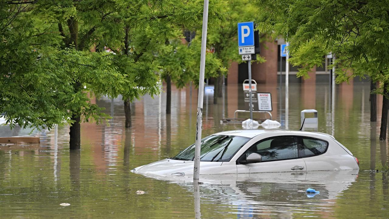 A picture taken in Cesena on May 17, 2023 shows a car in a flooded supermarket area after heavy rains have caused major floodings in central Italy, where trains were stopped and schools were closed in many towns while people were asked to leave the ground floors of their homes and to avoid going out. (Photo by Alessandro SERRANO / AFP)