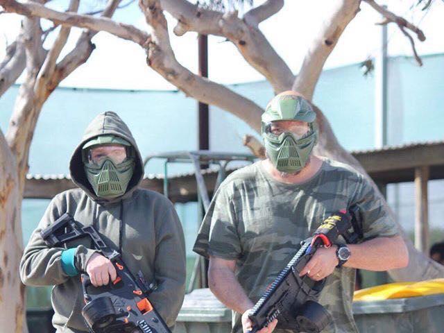 Two participants, one with an artificial leg, are fully kitted out in preparation for a CQ Blasters battle.