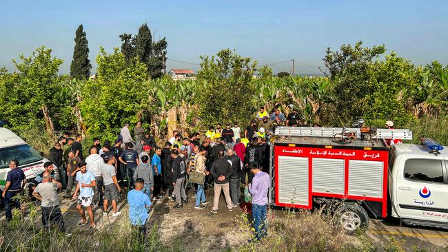 People gather at the site of an Israeli strike on a vehicle in the Adloun plain area, between Lebanon's southern cities of Sidon and Tyre, in April. Picture: Mahmoud Zayyat/AFP