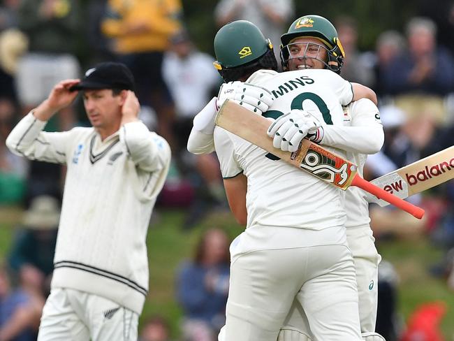 TOPSHOT - Australia's Pat Cummins (C) and Alex Carey (R) celebrate their victory on day four of the second Test cricket match between New Zealand and Australia at Hagley Oval in Christchurch on March 11, 2024. (Photo by Sanka Vidanagama / AFP)