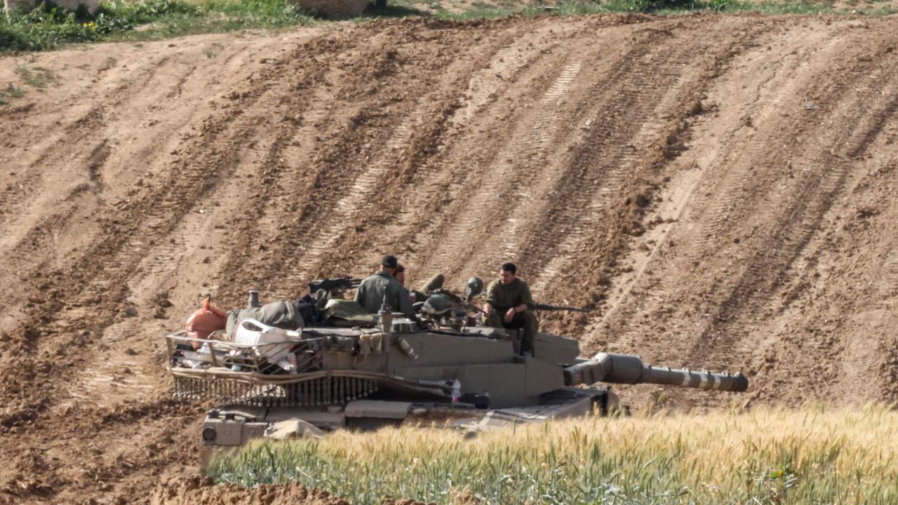 Israeli soldiers on top of a tank along the border with the Palestinian territory. Picture: Jack Guez / AFP