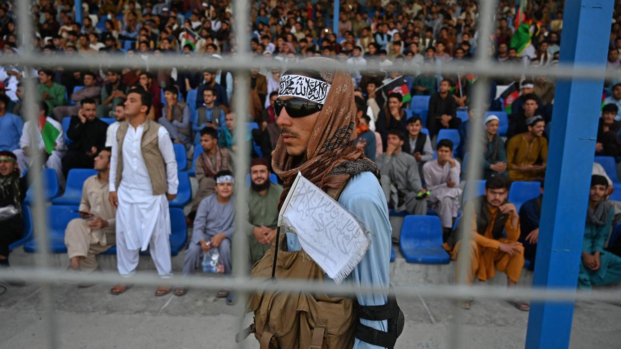 A Taliban fighter (C) keeps vigil as spectators watch the Twenty20 cricket trial match being played between two Afghan teams in Kabul on September 3, 2021. (Photo by Aamir QURESHI / AFP)