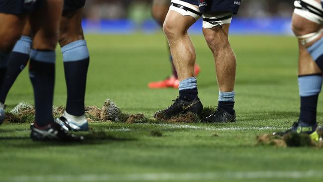 Players replace divots after a scrum during the clash between the Waratahs and Reds. Picture: Ryan Pierse/Getty Images