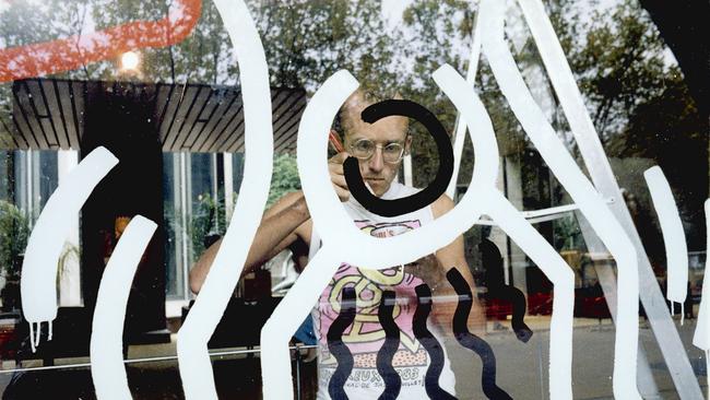 Keith Haring prepares an artwork on the waterwall at the NGV in 1984. Photo: Geoffrey Burke