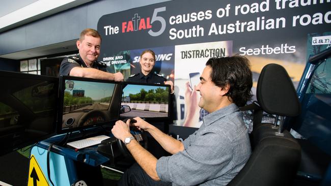 Superintendent Bob Gray, Senior Sergeant Susan O'Connor and David Penberthy, testing out the driving simulator which has been used at road safety seminars. Pic: Morgan Sette