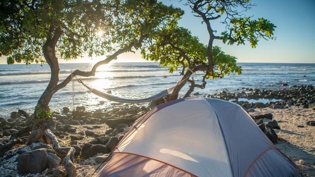 Tent on the beach at sunset, hammock hanging on trees. File picture