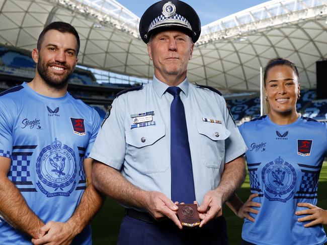 DAILY TELEGRAPH AUGUST 27, 2024. Roosters captains James Tedesco and Isabelle Kelly with NSW Police Assistant Commissioner Gavin Wood with the Commissioner medal that will be awarded to the player of the match at Allianz Stadium ahead of their Emergency Services NRL Event this weekend. Picture: Jonathan Ng