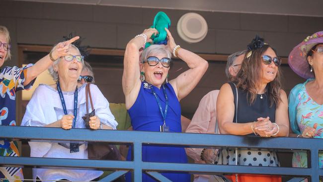 Annette Sullivan (centre) tangled up in blue at the Darwin Turf Club’s Metric Mile race day as she cheers on her horse. Picture: Glenn Campbell