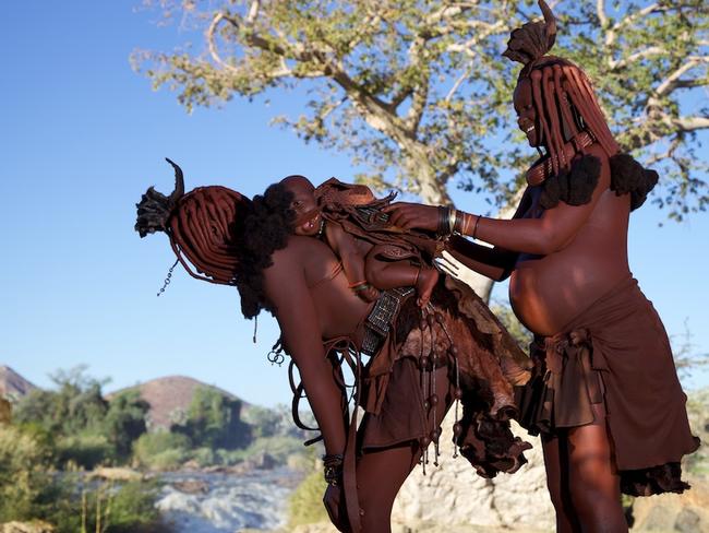 Young Himba mothers carrying their baby in traditional baby carriers looking over the Kunene river. Picture: Alegra Ally