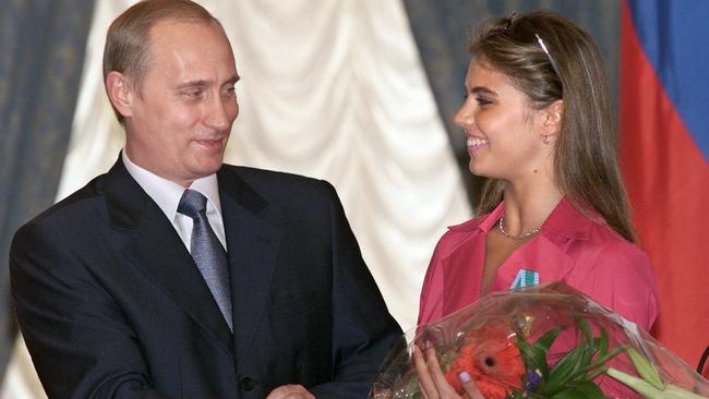 Vladimir Putin hands flowers to Alina Kabaeva. Picture: AFP