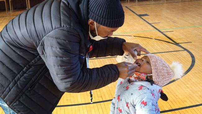 Samuel Cravens helps his daughter Azariah, 3, with a COVID-19 test in the Chicago neighbourhood of Englewoo on Thursday. Picture: Getty Images