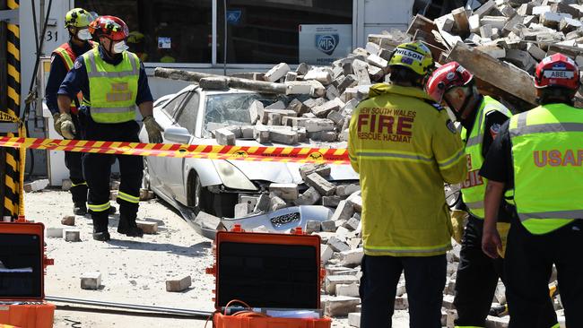 Emergency service crews at the scene where a wall collapsed on New Canterbury Road in Hurlstone Park. Picture: AAP