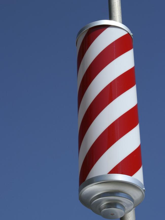 A traditional red-and-white striped barber shop pole.