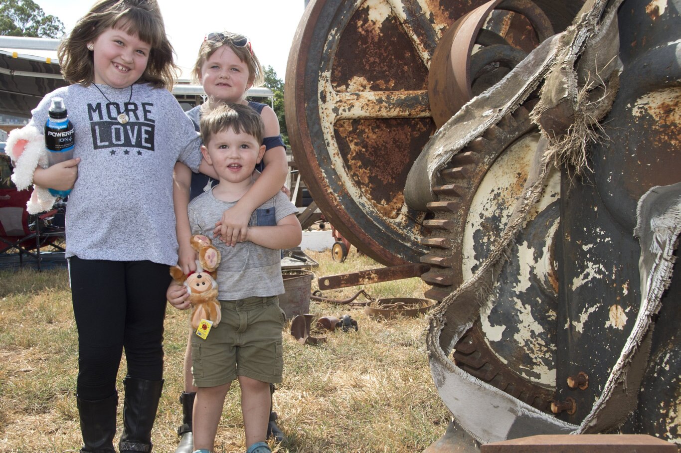Ella and Georgia Lewis and Spencer Burton standing next a Shear Metal Machine which was once used at the Toowoomba Foundry. Swap Meet at Showgrounds. February 2019. Picture: Bev Lacey
