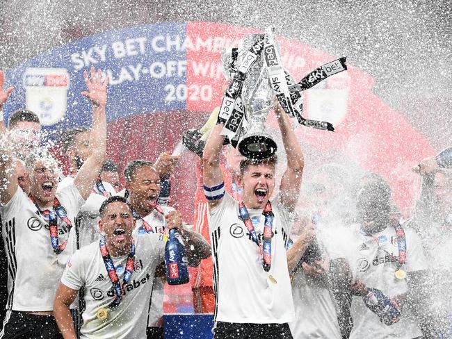 LONDON, ENGLAND - AUGUST 04: Tom Cairney of Fulham lifts the trophy as the team celebrate victory after during the Sky Bet Championship Play Off Final match between Brentford and Fulham at Wembley Stadium on August 04, 2020 in London, England. Football Stadiums around Europe remain empty due to the Coronavirus Pandemic as Government social distancing laws prohibit fans inside venues resulting in all fixtures being played behind closed doors. (Photo by Shaun Botterill/Getty Images)